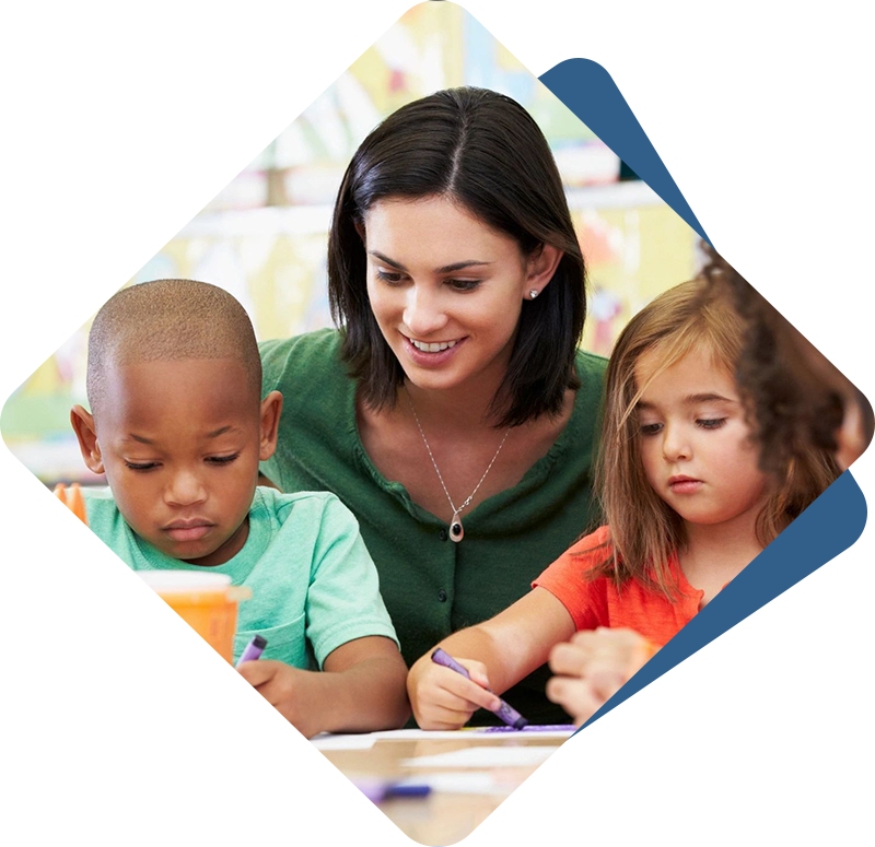 A woman is helping two children with their homework.